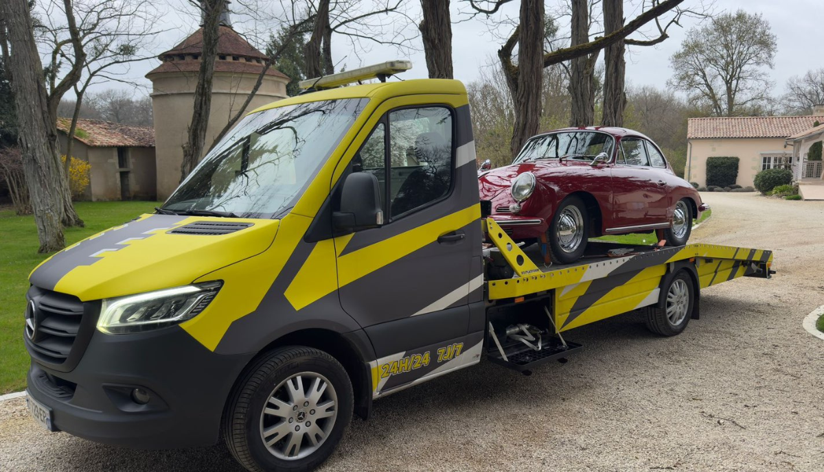 Dépannage et remorquage de véhicule à Angers Dépanneuse LVAutomobiles49 remorquant une voiture de collection rouge sur plateau à Angers (49)